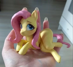 Size: 1125x1044 | Tagged: safe, artist:emysdraw, fluttershy, pegasus, pony, craft, female, hand, holding a pony, irl, lying down, mare, on side, photo, sculpture, solo