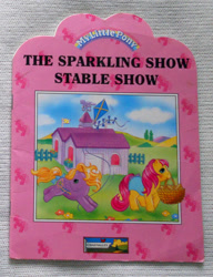 Size: 721x939 | Tagged: safe, earth pony, pegasus, pony, g1, official, baby, baby pony, basket, blushing, book, book cover, bow, cover, duo, duo female, female, fence, filly, foal, kite, stable, tail, tail bow, the sparkling show stable show