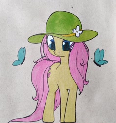 Size: 1213x1280 | Tagged: safe, artist:nutellaenjoyer, fluttershy, butterfly, pegasus, pony, g4, cute, female, full body, green hat, hat, looking at something, mare, paper background, solo, standing, traditional art, wingless