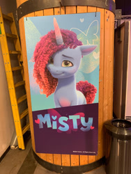 Size: 450x600 | Tagged: safe, misty brightdawn, butterfly, pony, unicorn, g5, colored belly, cute, daaaaaaaaaaaw, female, horn, irl, israel, looking at you, mare, mistybetes, my little pony cafe, name, photo, poster, rebirth misty, sign, smiling, solo