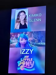 Size: 3000x4000 | Tagged: safe, screencap, izzy moonbow, human, unicorn, g5, my little pony: a new generation, spoiler:g5, caption, horn, image macro, kimiko glenn, photo, picture of a screen, solo, text, voice actor, voice actor joke