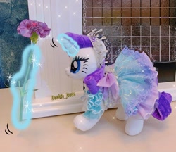 Size: 1500x1298 | Tagged: safe, rarity, pony, unicorn, g4, aura, clothes, dress, flower, glowing, glowing horn, hooves, horn, irl, jewelry, magic, magic aura, necklace, outfit, photo, plushie, pony plushie, princess rarity, raised hoof, solo