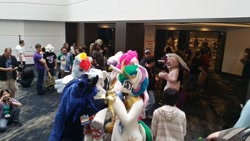 Size: 960x540 | Tagged: safe, derpy hooves, double diamond, gilda, pinkie pie, princess cadance, princess celestia, princess luna, rainbow dash, human, g4, convention, crowd, duo focus, female, fursuit, indoors, irl, irl human, jewelry, photo, ponysuit, regalia, royal sisters, siblings, sisters