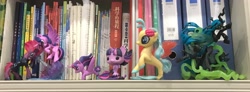 Size: 3544x1307 | Tagged: safe, photographer:jess181307, princess skystar, queen chrysalis, tempest shadow, twilight sparkle, alicorn, changeling, changeling queen, g4, book, bookshelf, chinese, funko, funko pop!, irl, photo, toy, twilight sparkle (alicorn)