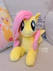 Size: 2552x3402 | Tagged: safe, reesee, applejack, fluttershy, pegasus, pony, g4, official, couch, double dove, irl, looking at you, lying down, merchandise, photo, pillow, plushie, pony plushie, smiling, smiling at you, text