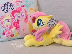 Size: 3363x2522 | Tagged: safe, reesee, applejack, fluttershy, pinkie pie, pegasus, pony, g4, official, couch, double dove, irl, looking at you, lying down, merchandise, open mouth, open smile, photo, pillow, plushie, pony plushie, smiling, smiling at you, text