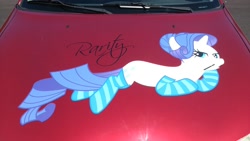 Size: 2400x1349 | Tagged: safe, rarity, pony, unicorn, galacon, g4, 2013, car, clothes, horn, irl, lying down, outdoors, photo, prone, socks, striped socks